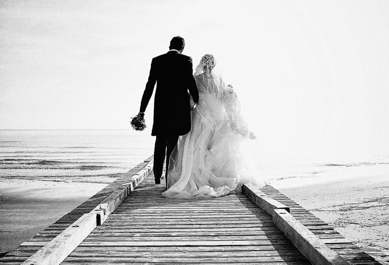 Servizio fotografico di matrimonio in stile reportage. Sposi su camminano su una passerella. Il Blog di Michelino Studio, Fotografo di matrimonio in Veneto.